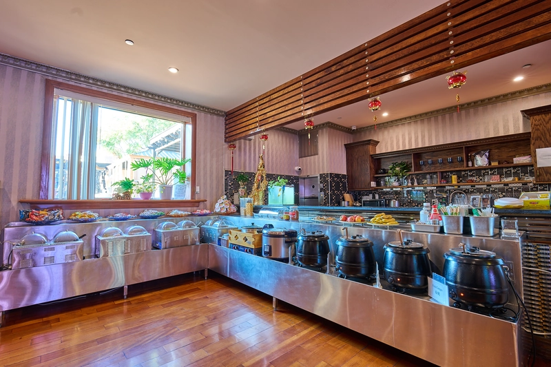 Buffet counter with hot dishes, soups, fruit and snacks